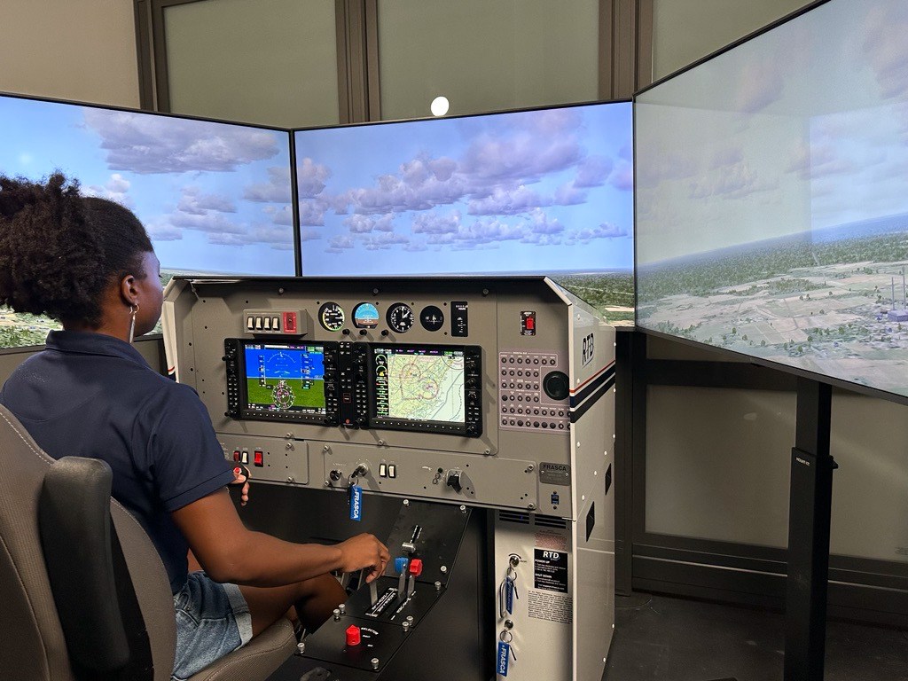 LIFT Academy flight simulator with student sitting in the flight simulator